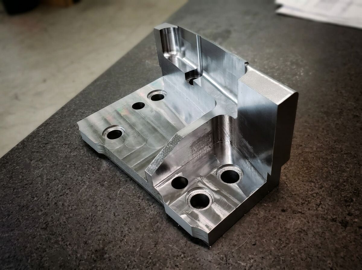 Machined aluminum block set up for dimensional inspection on a granite surface plate